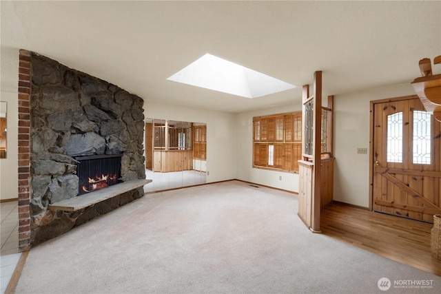 31312 179th Pl SE, Auburn, WA 98092 - unfurnished living room with a skylight, a stone fireplace, carpet, and wood finished floors