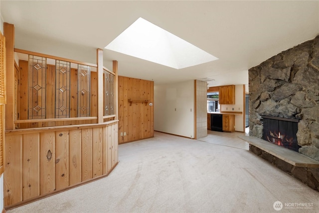 31312 179th Pl SE, Auburn, WA 98092 - unfurnished living room featuring a stone fireplace, a skylight, carpet floors, and wooden walls