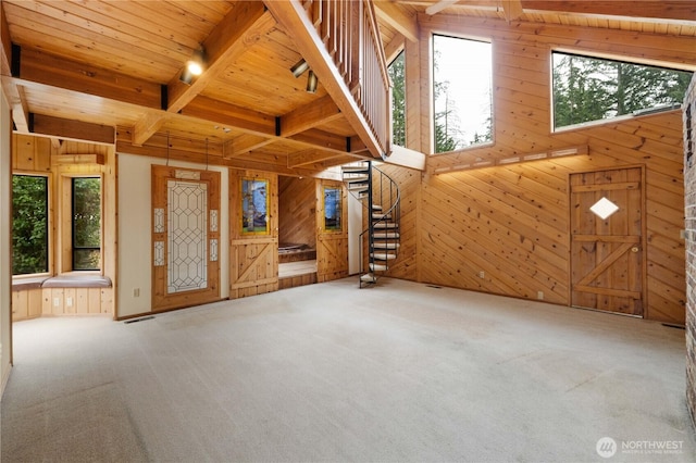 31312 179th Pl SE, Auburn, WA 98092 - unfurnished living room featuring wooden walls, carpet, healthy amount of natural light, a wooden ceiling with exposed beams, and stairway