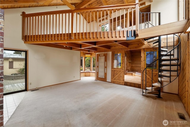 31312 179th Pl SE, Auburn, WA 98092 - unfurnished living room with high vaulted ceiling, carpet, wooden walls, and stairway