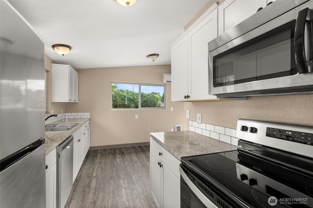 1428 S 4th Ave, Kelso, WA 98626 - kitchen featuring appliances with stainless steel finishes, wood finished floors, white cabinets, and lofted ceiling
