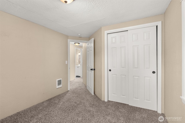 1428 S 4th Ave, Kelso, WA 98626 - unfurnished bedroom featuring carpet, a closet, and a textured ceiling