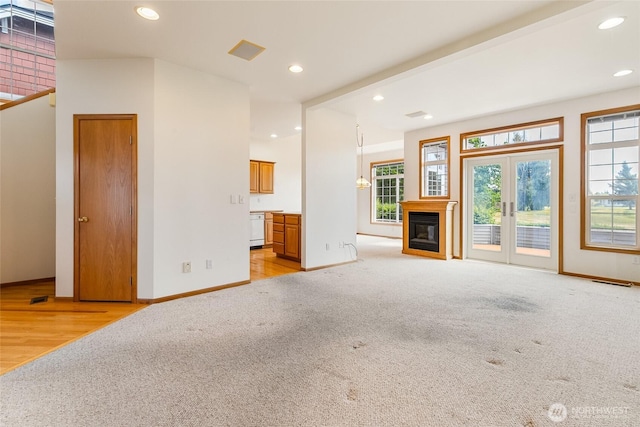 114 Twin Sister Loop, Lynden, WA 98264 - unfurnished living room with light colored carpet, recessed lighting, a glass covered fireplace, and light wood-type flooring