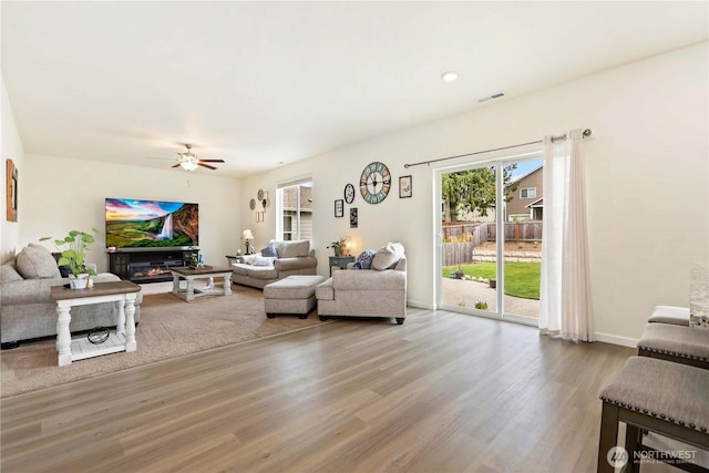 28515 76th Dr NW, Stanwood, WA 98292 - living room with wood finished floors, a ceiling fan, a glass covered fireplace, and recessed lighting