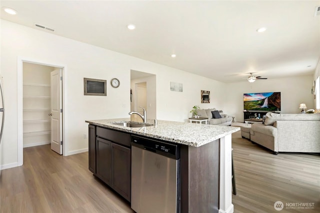 28515 76th Dr NW, Stanwood, WA 98292 - kitchen with dishwasher, light wood-style flooring, a ceiling fan, a kitchen island with sink, and light stone counters