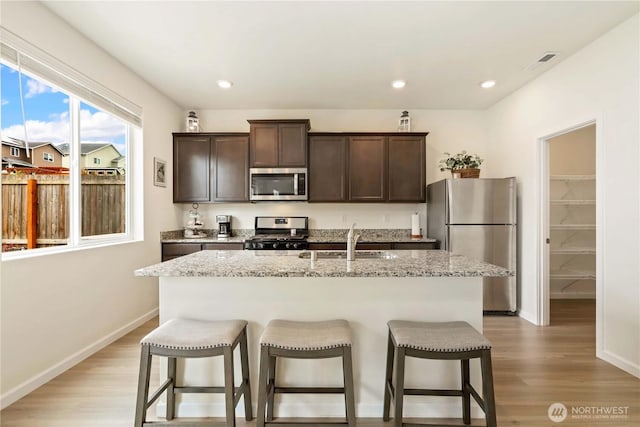 28515 76th Dr NW, Stanwood, WA 98292 - kitchen featuring stainless steel appliances, dark brown cabinets, a kitchen bar, and recessed lighting