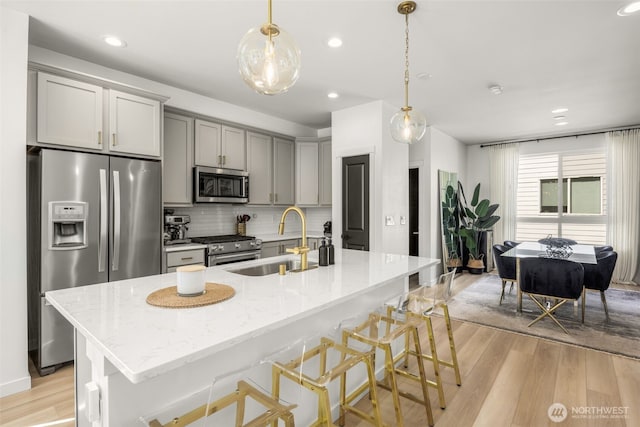 14646 35th Ct NE, Lake Forest Park, WA 98155 - kitchen featuring stainless steel appliances, gray cabinets, light wood-type flooring, tasteful backsplash, and light stone countertops