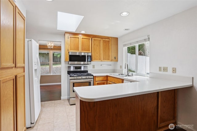 13940 113th Ave NE, Kirkland, WA 98034 - kitchen with appliances with stainless steel finishes, a skylight, a peninsula, light countertops, and light tile patterned floors