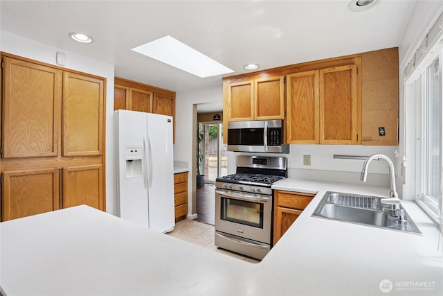 13940 113th Ave NE, Kirkland, WA 98034 - kitchen featuring stainless steel appliances, a skylight, light countertops, light tile patterned flooring, and recessed lighting