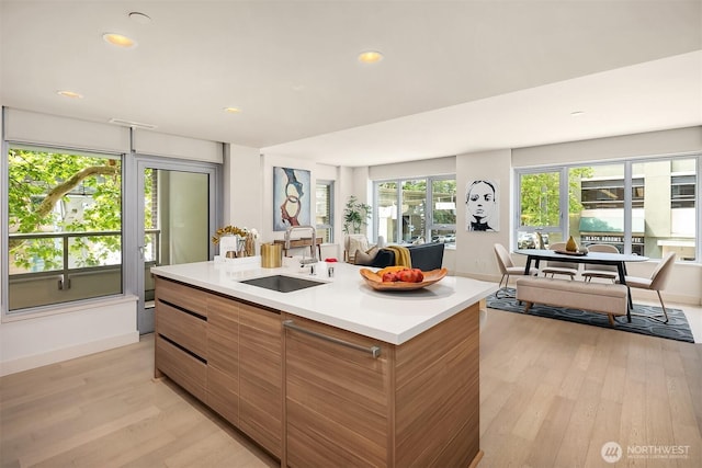 583 Battery St Unit 212N, Seattle, WA 98121 - kitchen with modern cabinets, light wood finished floors, light countertops, recessed lighting, and a kitchen island with sink