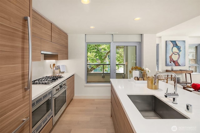 583 Battery St Unit 212N, Seattle, WA 98121 - kitchen with appliances with stainless steel finishes, modern cabinets, brown cabinets, light countertops, and light wood-style flooring
