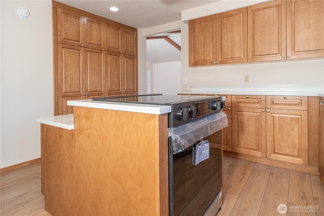 2289 Towne Point Ave, Port Townsend, WA 98368 - kitchen featuring range with electric stovetop, light wood finished floors, a center island, brown cabinets, and recessed lighting