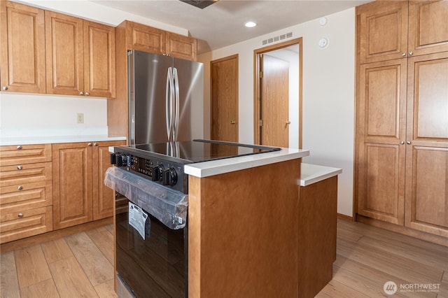 2289 Towne Point Ave, Port Townsend, WA 98368 - kitchen with freestanding refrigerator, black electric range oven, light wood-style floors, a kitchen island, and recessed lighting