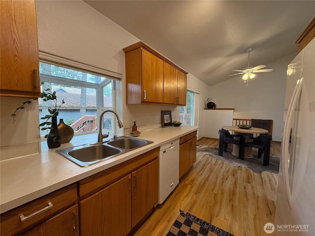 933 Fern St SW, Olympia, WA 98502 - kitchen featuring white appliances, lofted ceiling, light countertops, light wood-style flooring, and brown cabinetry