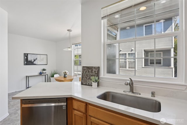 352 227th Ln NE Unit 142, Sammamish, WA 98074 - kitchen featuring stainless steel dishwasher, light countertops, brown cabinetry, hanging light fixtures, and a peninsula