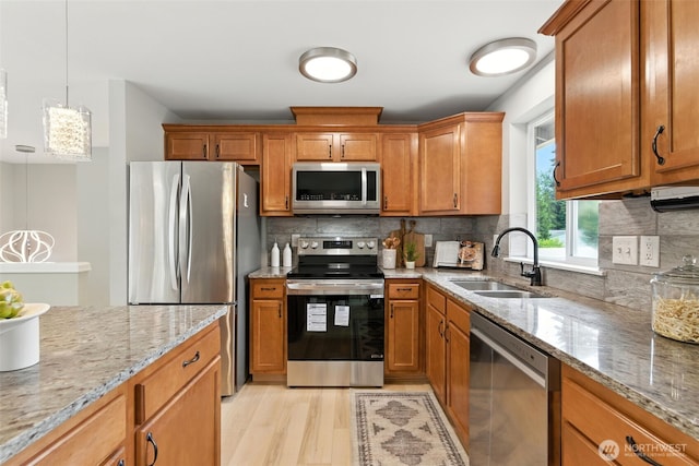21905 128th St E, Bonney Lake, WA 98391 - kitchen featuring stainless steel appliances, light wood-type flooring, and brown cabinets