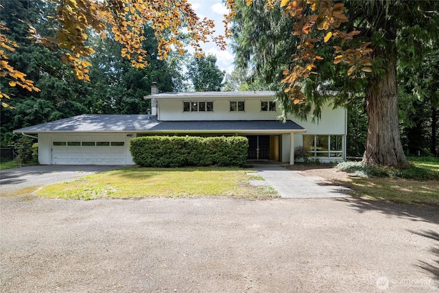 3928 Sorenson Rd, Everson, WA 98247 - view of front of house with driveway, a chimney, a garage, stucco siding, and a front lawn