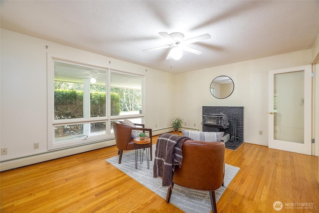 3928 Sorenson Rd, Everson, WA 98247 - living room with ceiling fan, light wood-style flooring, a baseboard radiator, and a textured ceiling