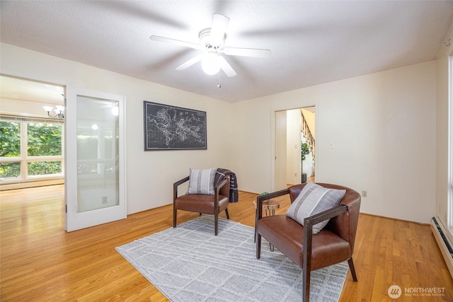 3928 Sorenson Rd, Everson, WA 98247 - living area with light wood finished floors, a baseboard heating unit, a chandelier, a ceiling fan, and baseboard heating