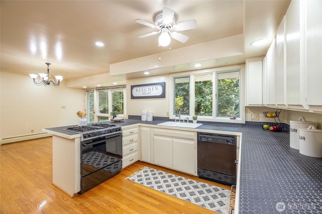 3928 Sorenson Rd, Everson, WA 98247 - kitchen with black appliances, baseboard heating, a peninsula, white cabinetry, and plenty of natural light