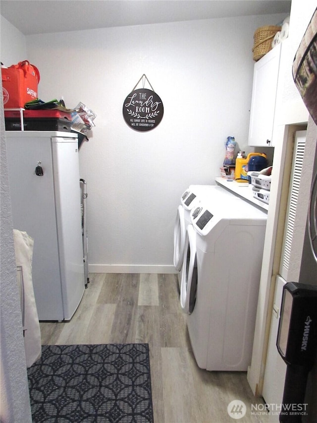 4917 107th Ave SE, Snohomish, WA 98290 - laundry area featuring washing machine and clothes dryer, cabinet space, and light wood-style flooring