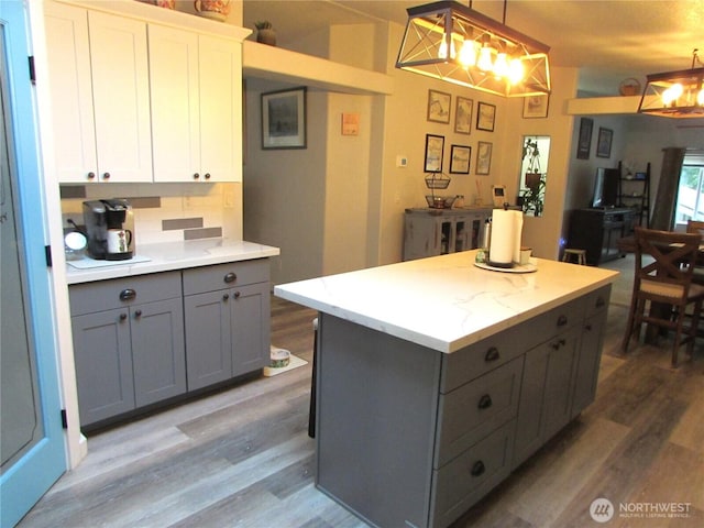 4917 107th Ave SE, Snohomish, WA 98290 - kitchen with gray cabinetry, light wood-type flooring, a kitchen island, decorative light fixtures, and a chandelier