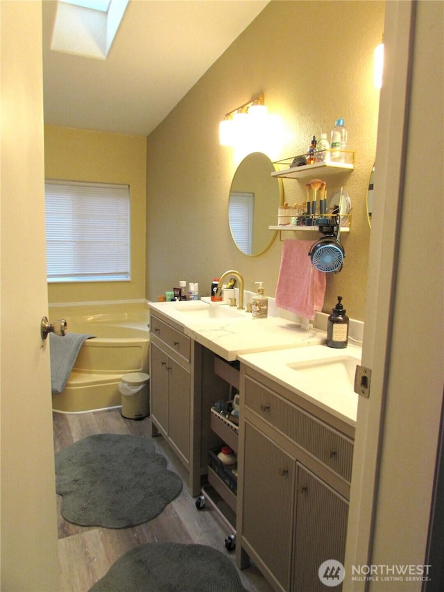 4917 107th Ave SE, Snohomish, WA 98290 - full bath with vanity, wood finished floors, a bath, a skylight, and vaulted ceiling