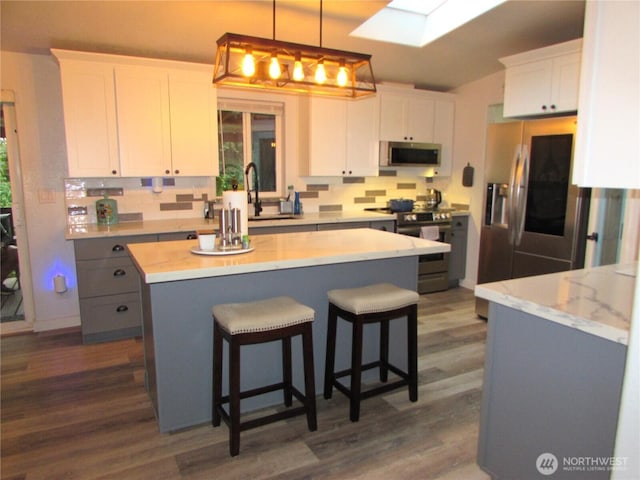 4917 107th Ave SE, Snohomish, WA 98290 - kitchen featuring stainless steel appliances, dark wood-style flooring, white cabinets, and tasteful backsplash