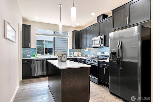 6855 NE 170th St Unit 102, Kenmore, WA 98028 - kitchen featuring appliances with stainless steel finishes, light countertops, decorative backsplash, light wood-style flooring, and recessed lighting