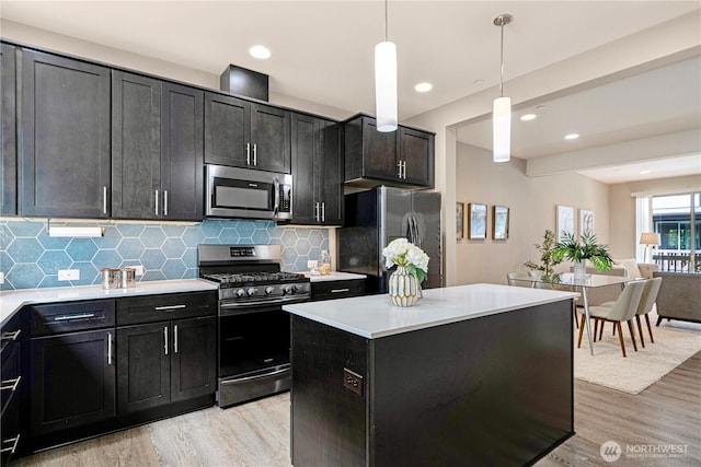 6855 NE 170th St Unit 102, Kenmore, WA 98028 - kitchen with appliances with stainless steel finishes, light wood-style flooring, backsplash, light countertops, and dark cabinetry