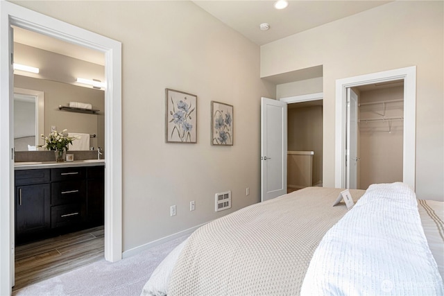 6855 NE 170th St Unit 102, Kenmore, WA 98028 - bedroom featuring light colored carpet, a walk in closet, and connected bathroom
