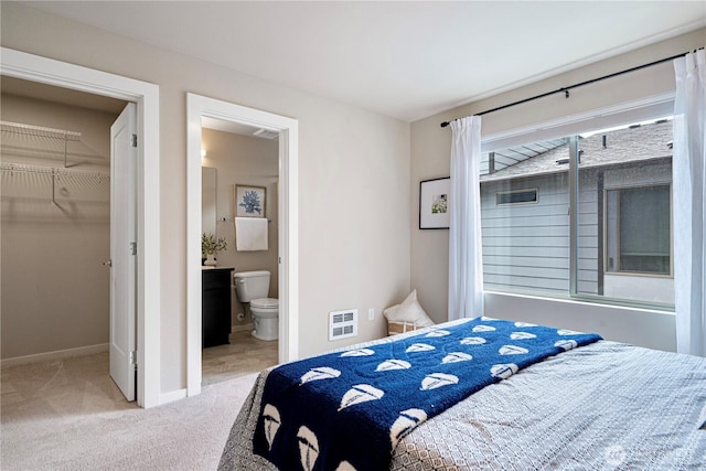 6855 NE 170th St Unit 102, Kenmore, WA 98028 - carpeted bedroom featuring a walk in closet, ensuite bath, and heating unit
