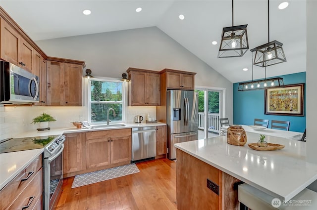 13506 89th Pl NE, Kirkland, WA 98034 - kitchen with stainless steel appliances, high vaulted ceiling, light countertops, pendant lighting, and light wood-style flooring