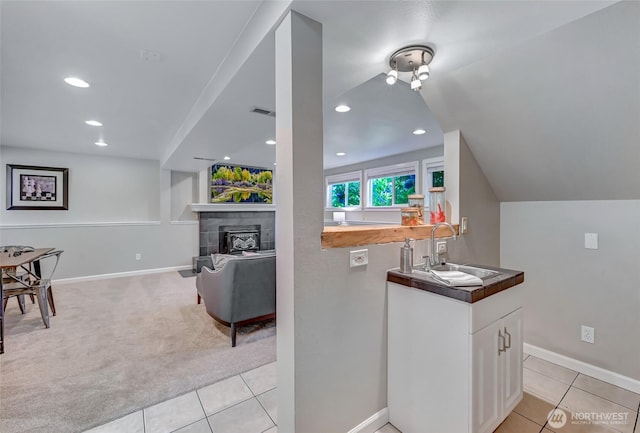 13506 89th Pl NE, Kirkland, WA 98034 - kitchen with white cabinetry, light tile patterned floors, light colored carpet, a fireplace, and recessed lighting