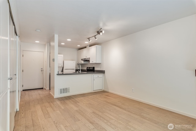 211 E Summit Ave Unit S117, Seattle, WA 98102 - kitchen featuring freestanding refrigerator, dark countertops, under cabinet range hood, light wood-style floors, and recessed lighting