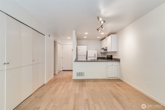 211 E Summit Ave Unit S117, Seattle, WA 98102 - kitchen featuring dark countertops, light wood-style floors, stainless steel electric range oven, recessed lighting, and white cabinets