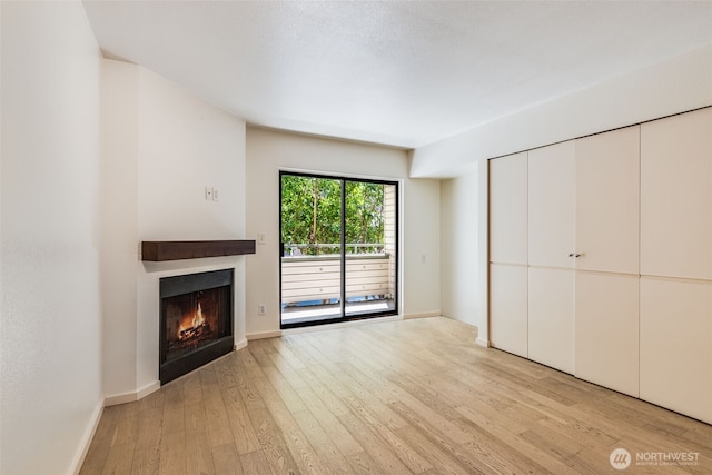 211 E Summit Ave Unit S117, Seattle, WA 98102 - unfurnished living room featuring light wood-style flooring and a warm lit fireplace