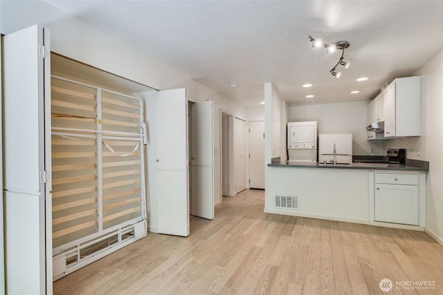211 E Summit Ave Unit S117, Seattle, WA 98102 - kitchen featuring stacked washer and clothes dryer, dark countertops, under cabinet range hood, stainless steel electric stove, and recessed lighting