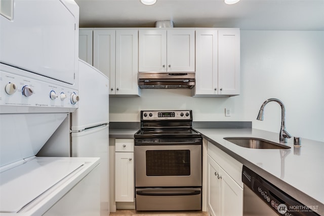 211 E Summit Ave Unit S117, Seattle, WA 98102 - kitchen featuring stainless steel appliances, under cabinet range hood, estacked washer and dryer, and white cabinetry