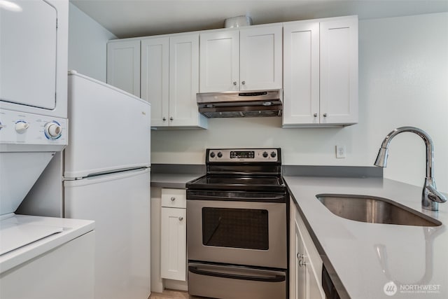 211 E Summit Ave Unit S117, Seattle, WA 98102 - kitchen with under cabinet range hood, stainless steel electric range, white cabinetry, and freestanding refrigerator