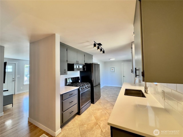 30135 2nd Ave SW, Federal Way, WA 98023 - kitchen featuring appliances with stainless steel finishes, rail lighting, light countertops, decorative backsplash, and gray cabinets
