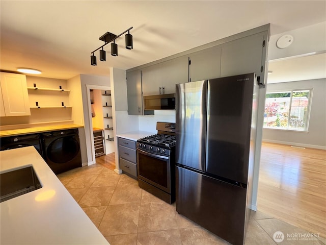 30135 2nd Ave SW, Federal Way, WA 98023 - kitchen with stainless steel appliances, washer / dryer, light countertops, and light tile patterned floors