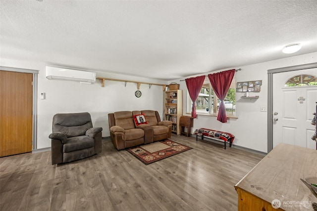 17112 Kinnikinnick Ct SE, Yelm, WA 98597 - living room featuring a wall unit AC, wood finished floors, a textured ceiling, and plenty of natural light