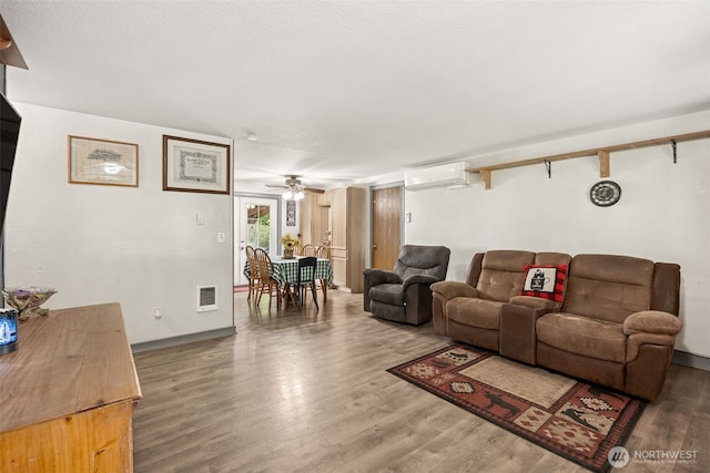 17112 Kinnikinnick Ct SE, Yelm, WA 98597 - living area featuring a wall mounted air conditioner, wood finished floors, and a ceiling fan