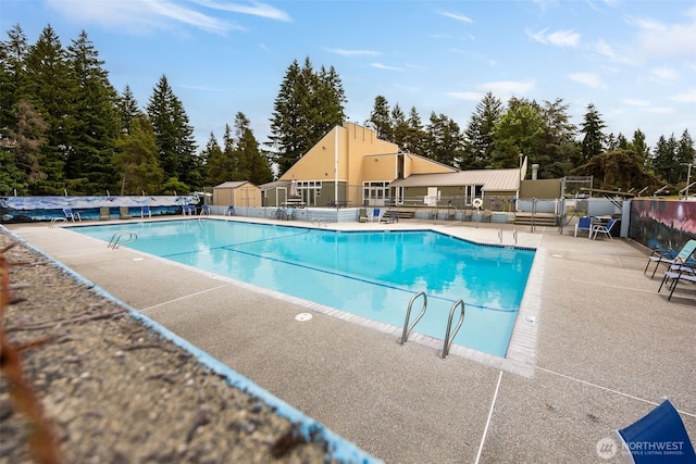 17112 Kinnikinnick Ct SE, Yelm, WA 98597 - community pool with a patio, a shed, and view of wooded area