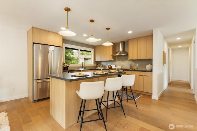 21 165th Ave SE, Bellevue, WA 98008 - kitchen with high end refrigerator, light brown cabinetry, wall chimney exhaust hood, dark countertops, and recessed lighting