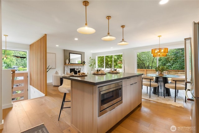 21 165th Ave SE, Bellevue, WA 98008 - kitchen with appliances with stainless steel finishes, dark countertops, light wood-style floors, a kitchen breakfast bar, and recessed lighting
