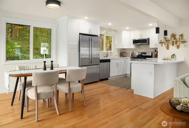 8004 203rd Pl SW, Edmonds, WA 98026 - kitchen featuring appliances with stainless steel finishes, a peninsula, decorative backsplash, white cabinets, and recessed lighting