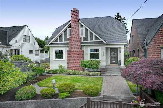2663 37th Ave SW, Seattle, WA 98126 - tudor-style house featuring roof with shingles, a chimney, and entry steps