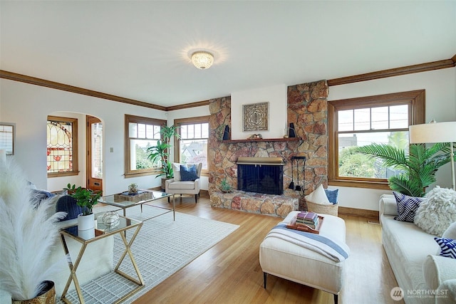 2663 37th Ave SW, Seattle, WA 98126 - living area with arched walkways, a stone fireplace, ornamental molding, and wood finished floors